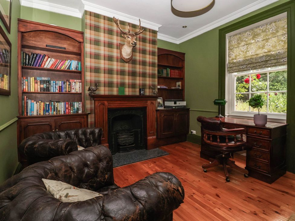 An office with a bookshelf and fireplace at Kexby House