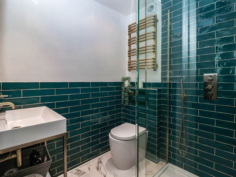 A bathroom with a sink, toilet, and shower at Kexby House