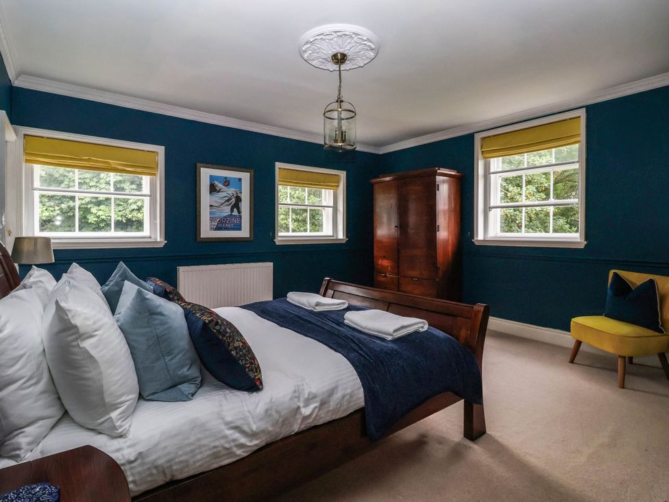 A bedroom with a bed and wardrobe at Kexby House