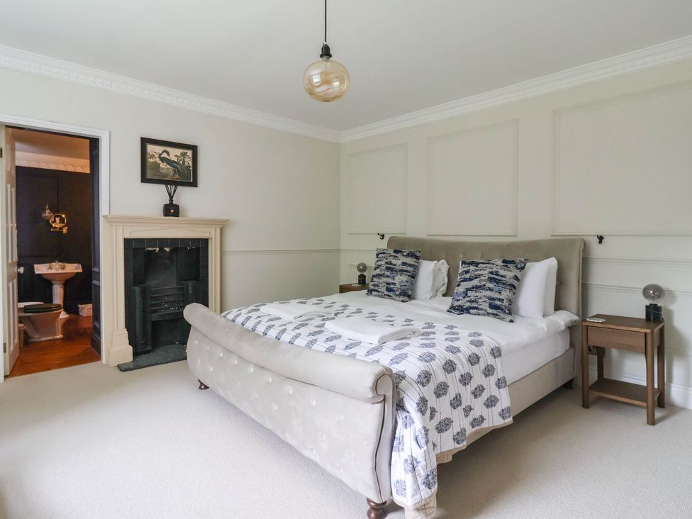 A bedroom with a bed and bedside tables at Kexby House