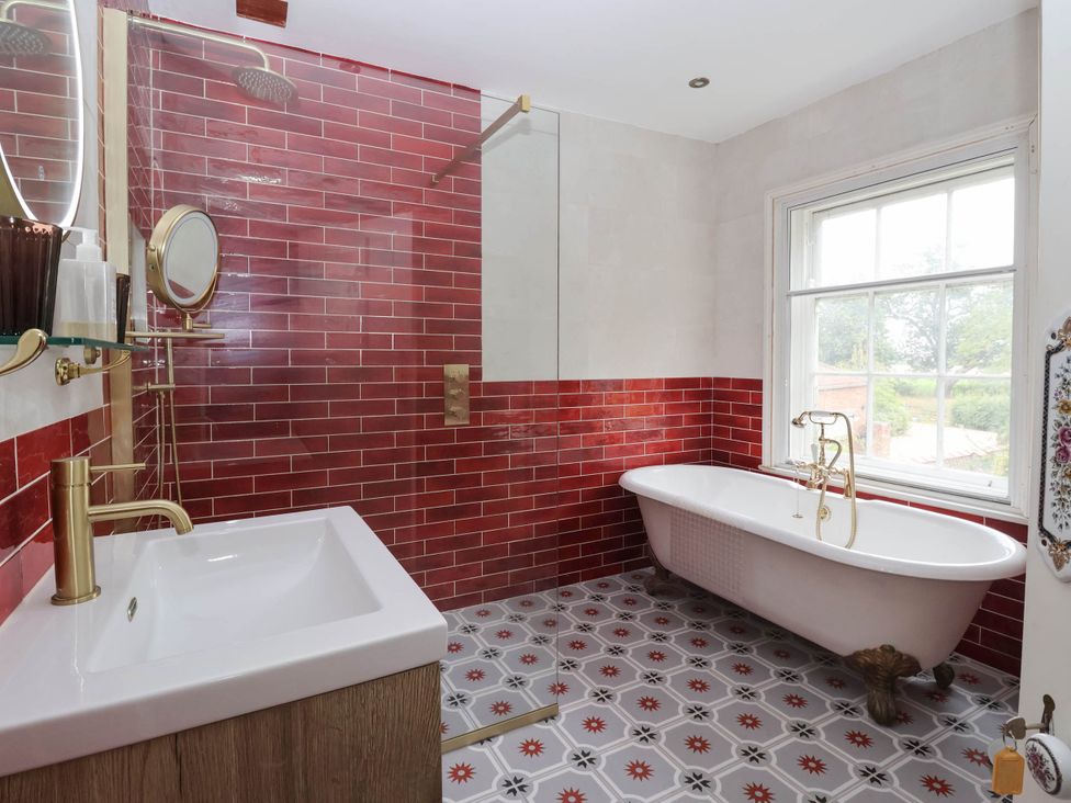 A bathroom with a shower, bathtub, and sink at Kexby House