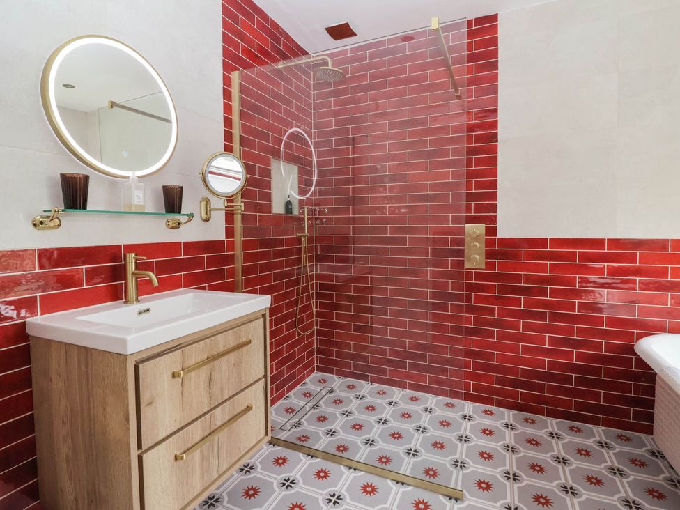A bathroom with a shower and wooden vanity at Kexby House