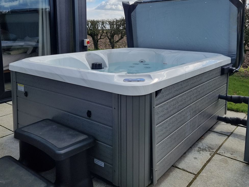A hot tub with steps and controls in the garden at Skylark Bishop Wilton