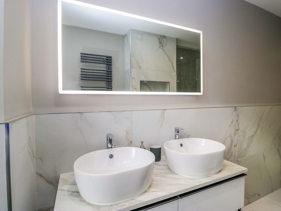 A bathroom with double sinks and a mirror at Beckmead in Windermere