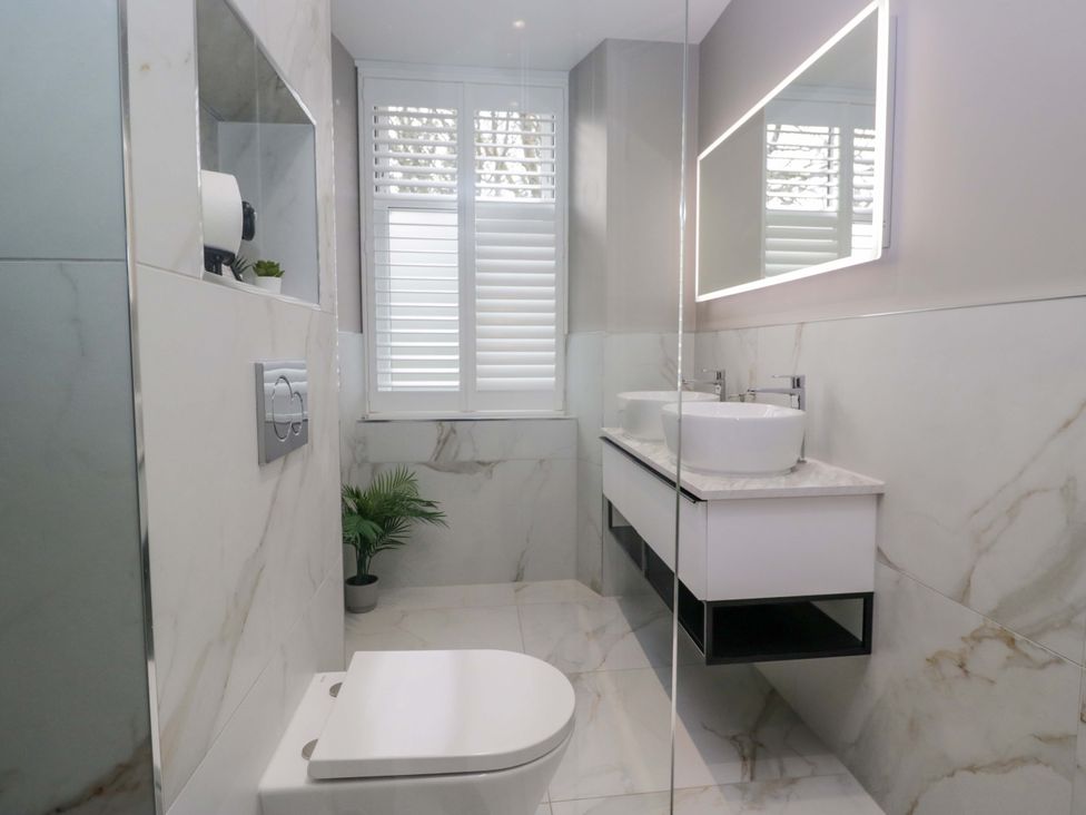 A bathroom with a toilet and sink at Beckmead in Windermere