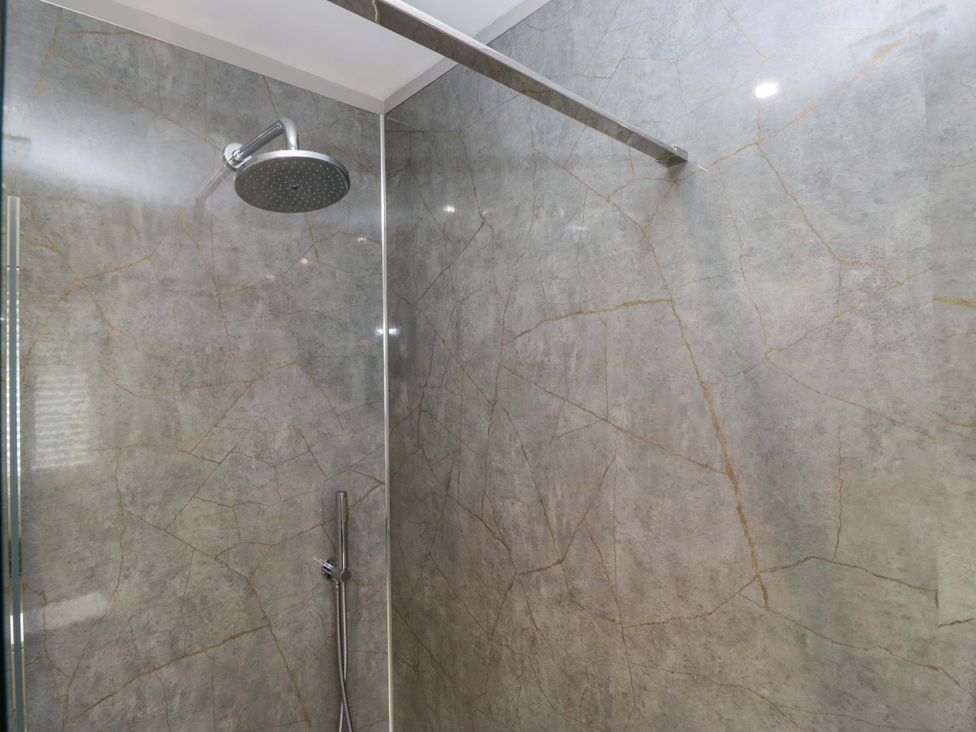 A shower with stone walls and fixtures at Beckmead in Windermere