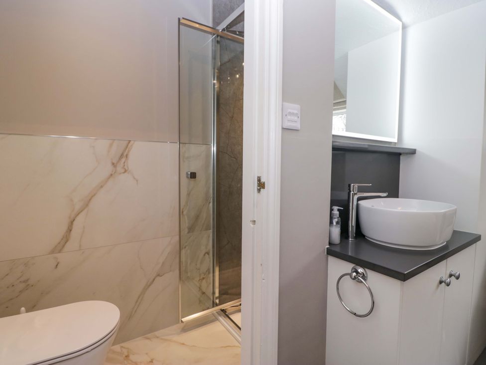 A bathroom with a shower and sink at Beckmead in Windermere