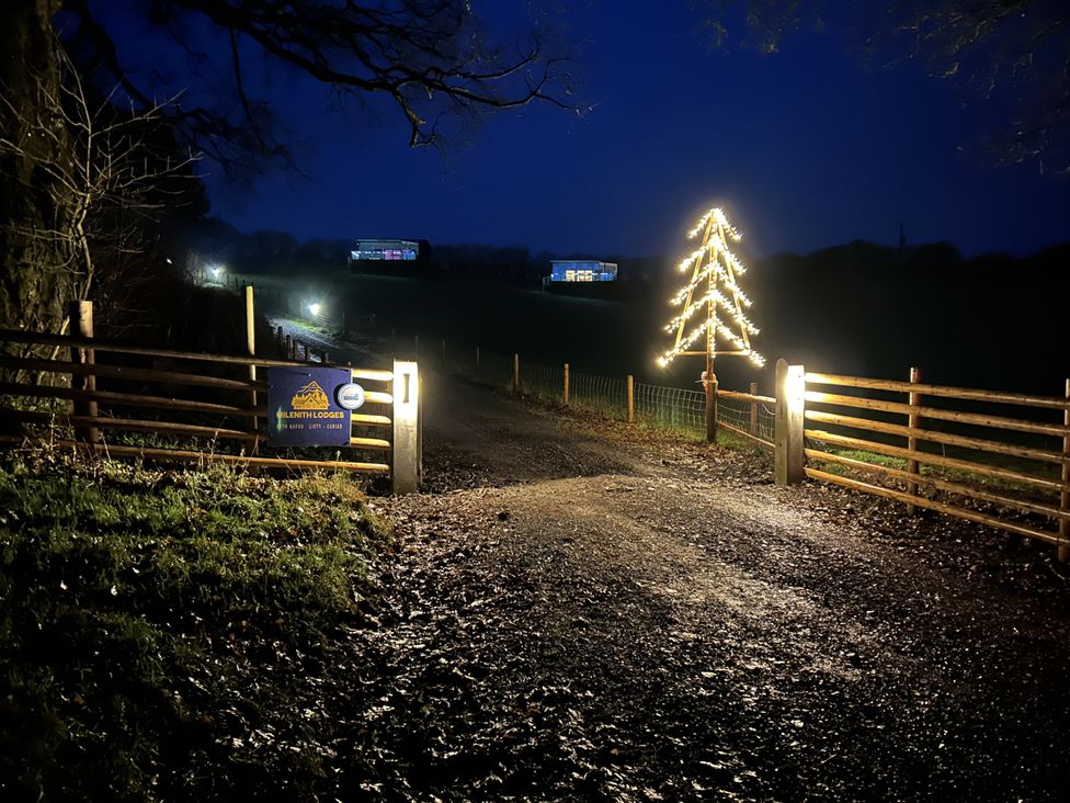 A pathway with a lit Christmas tree and a sign at Llenthil Lodges in Llandrindod Wells