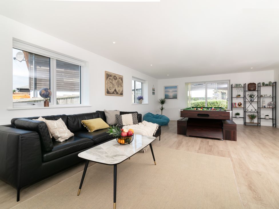 A living room with a pool table and seating area at Sandy Cove in Praa Sands