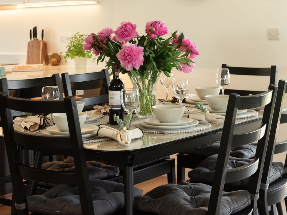 A dining room with a table set for dinner at Sandy Cove in Praa Sands