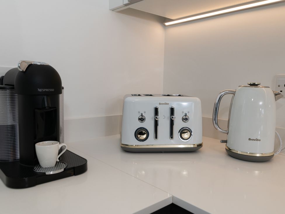 A kitchen with a Nespresso machine, kettle, toaster, and coffee cup at Sandy Cove in Praa Sands