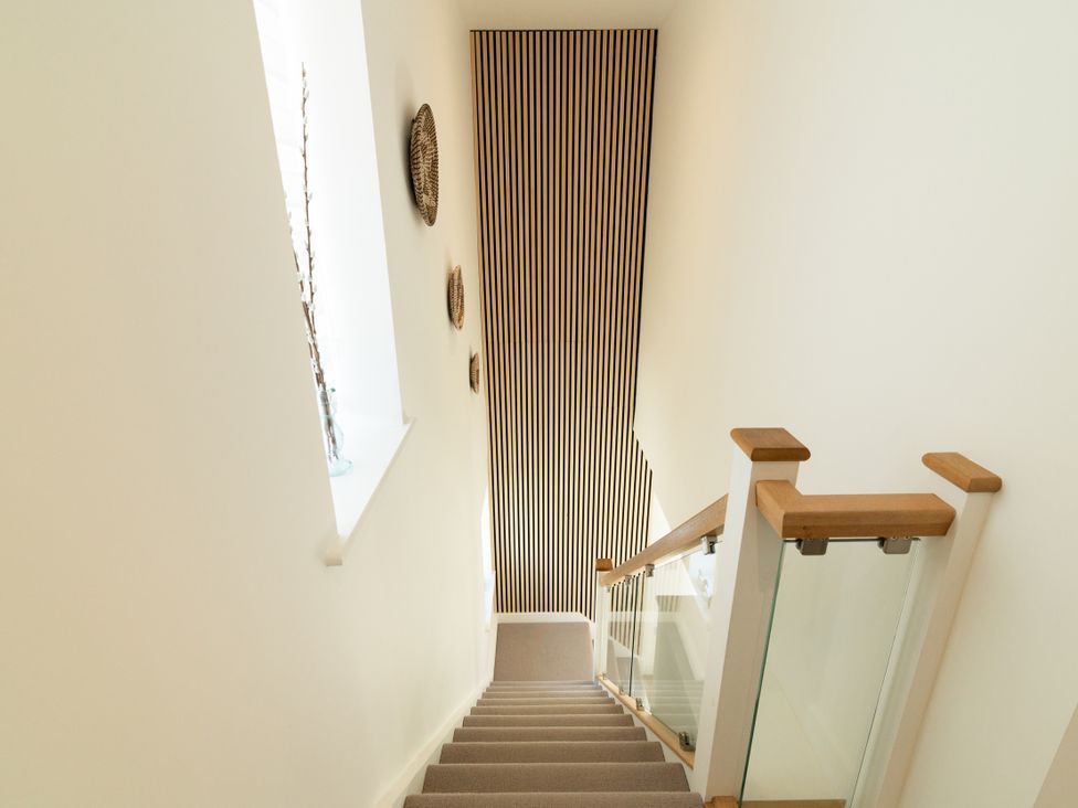 A stairwell with a staircase and decorative wall elements at Sandy Cove in Praa Sands
