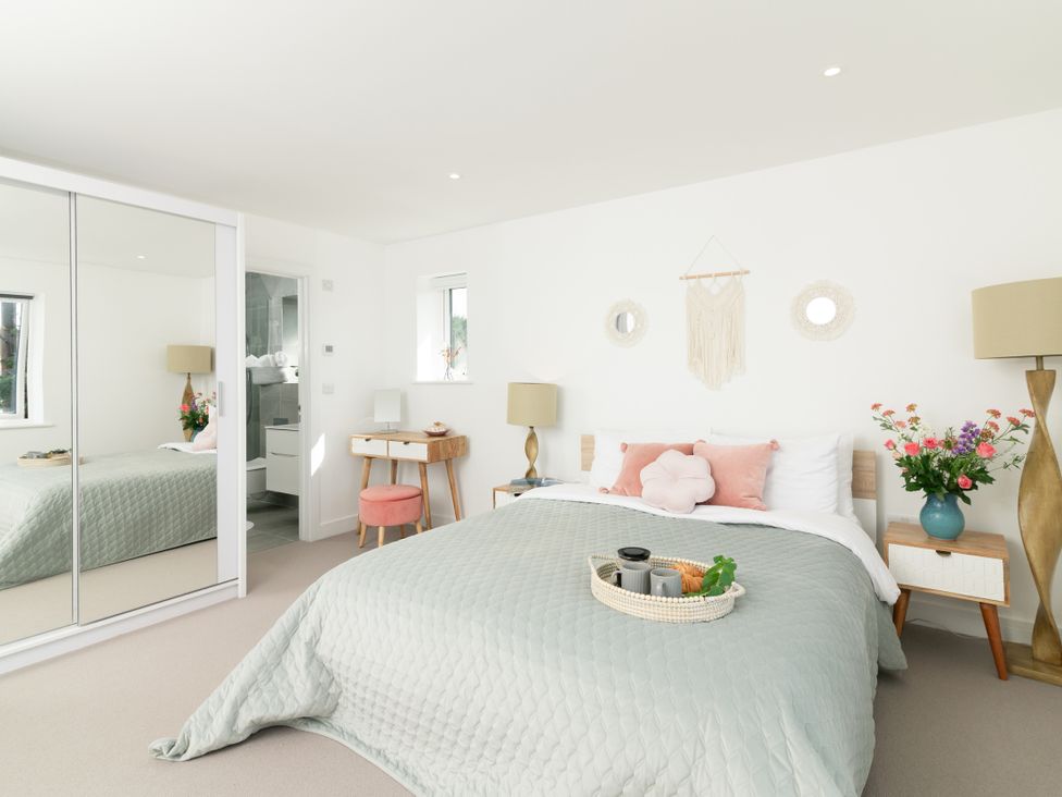 A bedroom with a bed and side table at Sandy Cove in Praa Sands