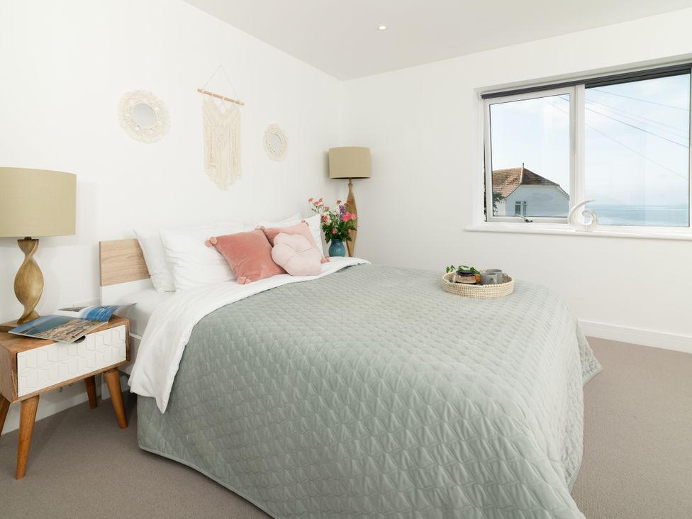A bedroom with a bed and a window at Sandy Cove in Praa Sands
