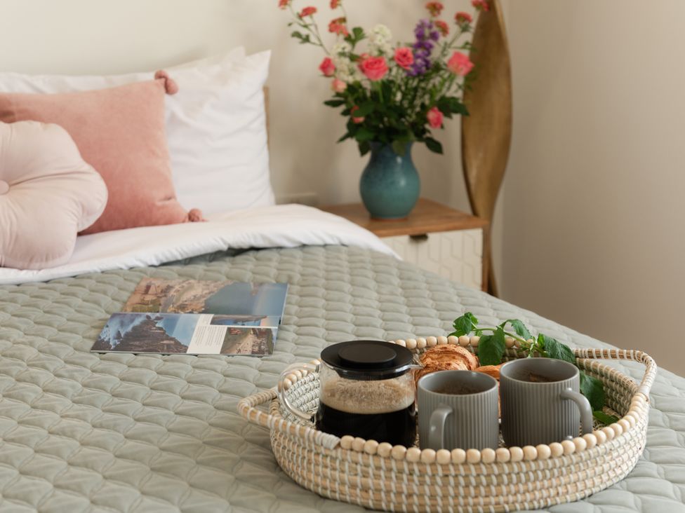 A bedroom with a bed and a tray of coffee at Sandy Cove in Praa Sands