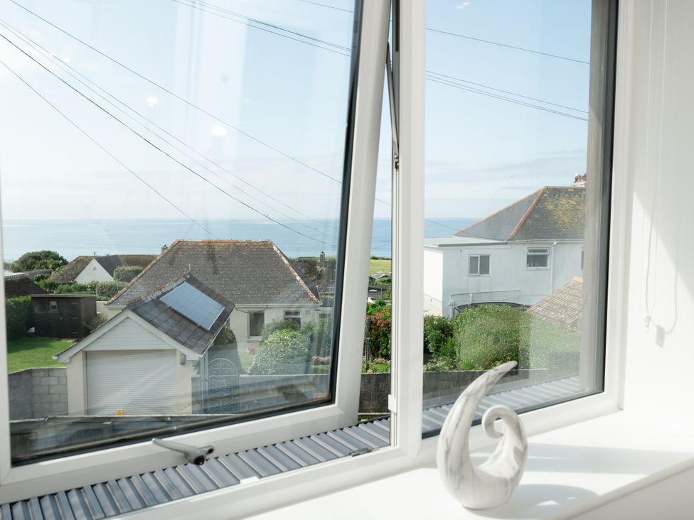 A view of the ocean and houses from a window at Sandy Cove in Praa Sands