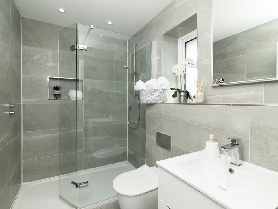 A bathroom with a shower, sink, and toilet at Sandy Cove in Praa Sands