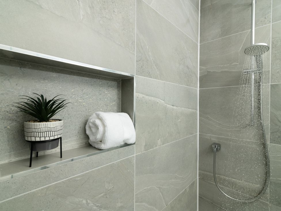 A shower area with a towel and a plant at Sandy Cove in Praa Sands