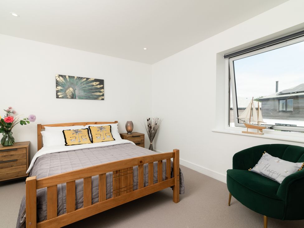 A bedroom with a bed and nightstands at Sandy Cove in Praa Sands