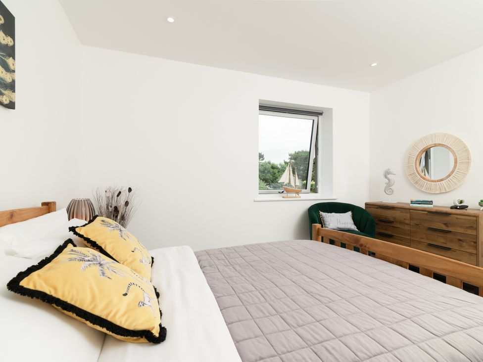 A bedroom with a bed and window at Sandy Cove, Praa Sands
