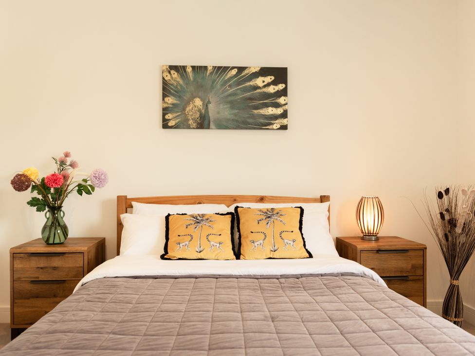 A bedroom with a bed and nightstands at Sandy Cove in Praa Sands