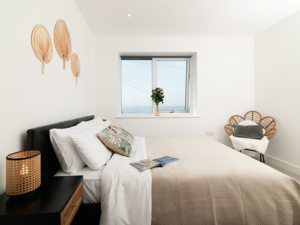 A bedroom with a bed and window at Sandy Cove in Praa Sands