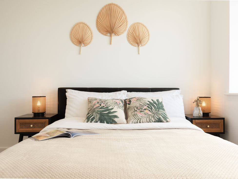 A bedroom with a bed and decorative pillows at Sandy Cove in Praa Sands