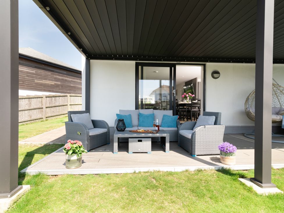 An outdoor seating area with a sofa and coffee table at Sandy Cove in Praa Sands