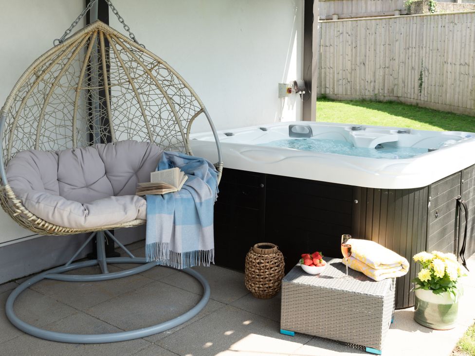 An outdoor area with a hanging chair and a hot tub at Sandy Cove in Praa Sands