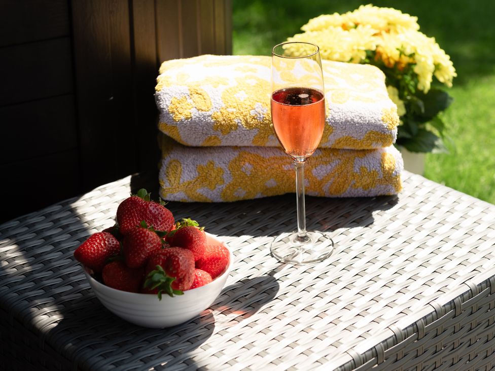 A champagne glass, strawberries, and towels on a table at Sandy Cove in Praa Sands
