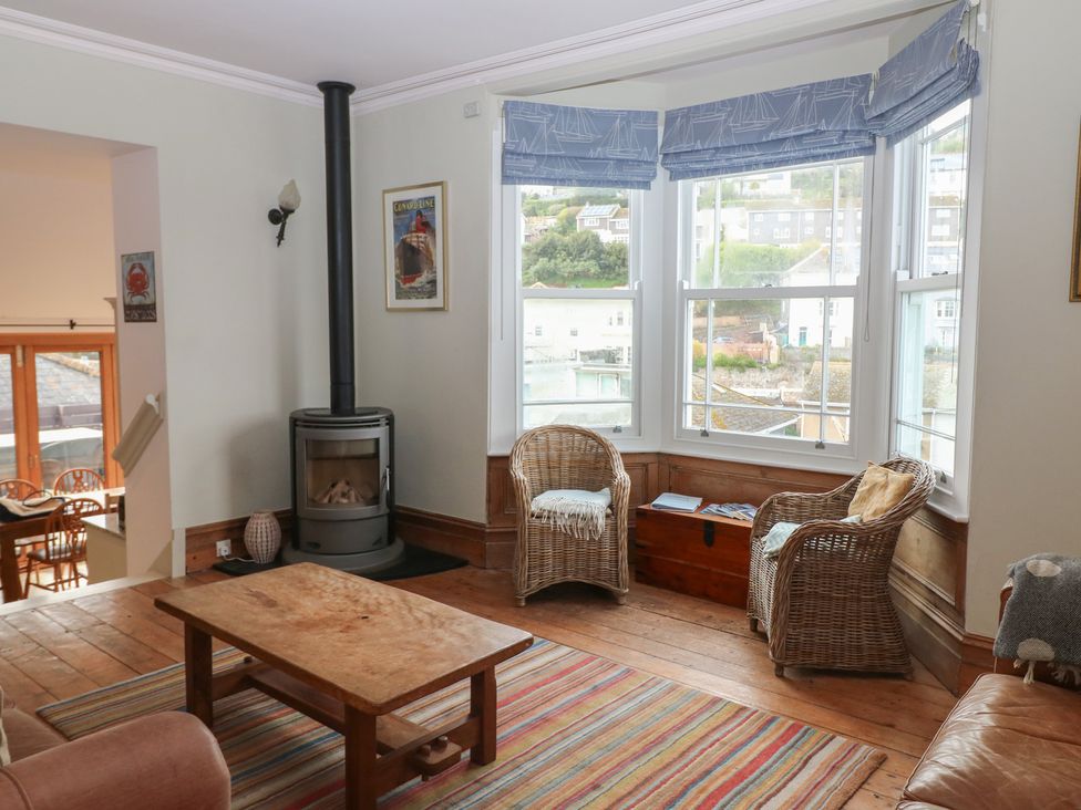 A living room with wicker chairs and a wooden table at Kipper Lodge in Dartmouth