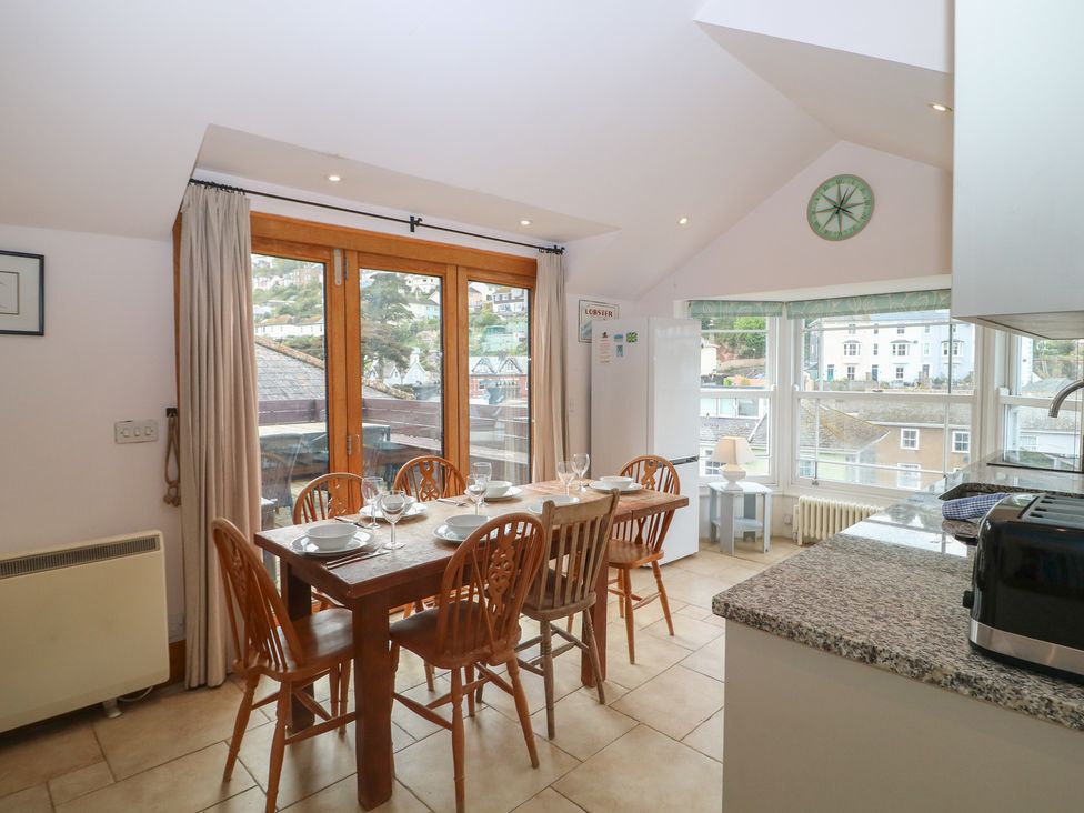 A kitchen with dining table and chairs at Kipper Lodge in Dartmouth