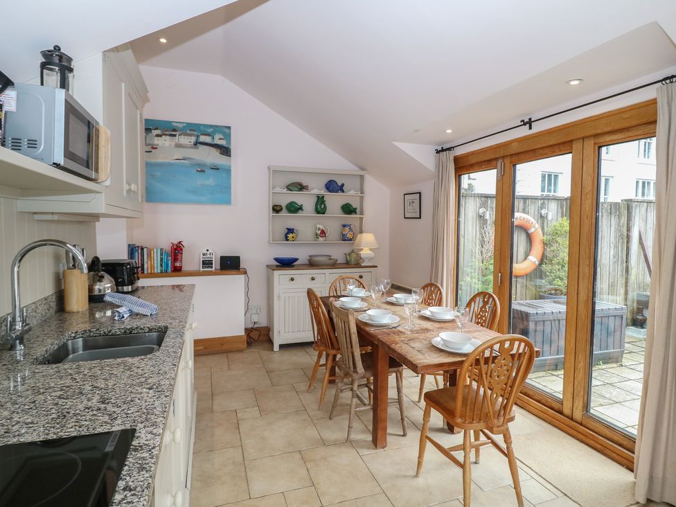 A kitchen with a dining table and patio doors at Kipper Lodge Dartmouth