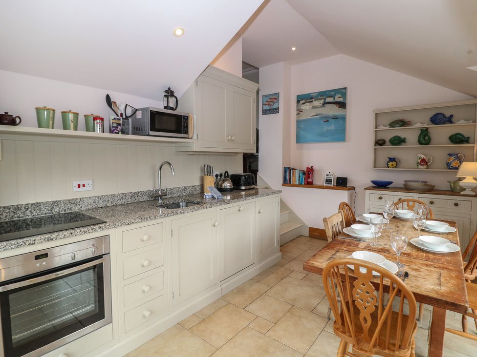A kitchen with appliances and dining table at Kipper Lodge in Dartmouth