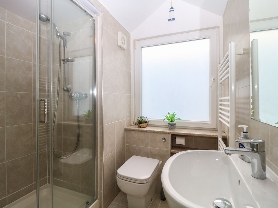 A bathroom with a shower, sink, and toilet at Kipper Lodge in Dartmouth