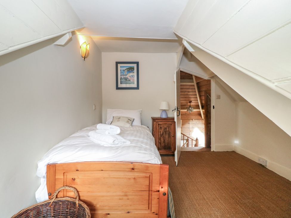 A bedroom with a bed and cupboard at Kipper Lodge Dartmouth