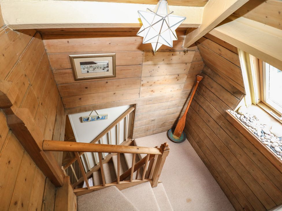 A staircase with wooden walls and a window at Kipper Lodge in Dartmouth