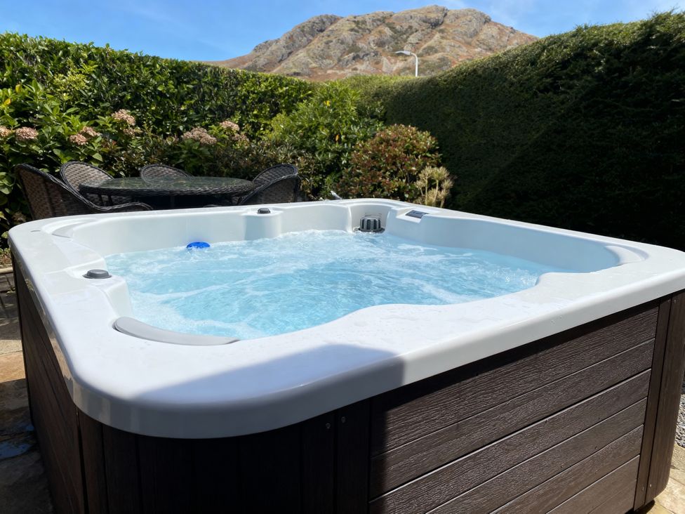 A hot tub with water and outdoor furniture at Holme Fell in Coniston