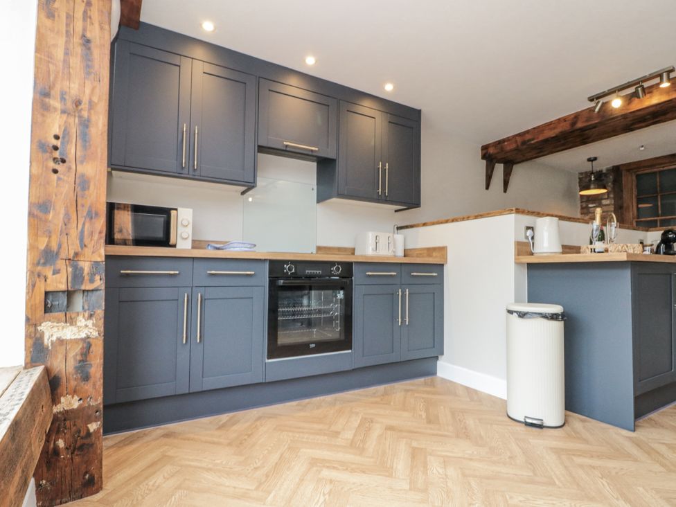 A kitchen with cabinets, oven and microwave at Betsy's Burrow