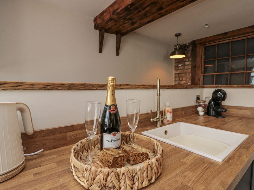 A kitchen with champagne and glasses on wooden countertop at Betsy's Burrow