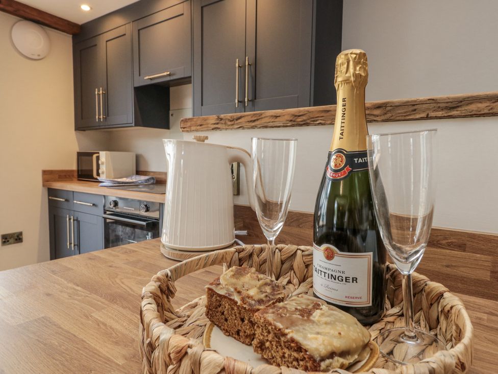 A kitchen with a kettle and champagne in glasses at Betsy's Burrow 