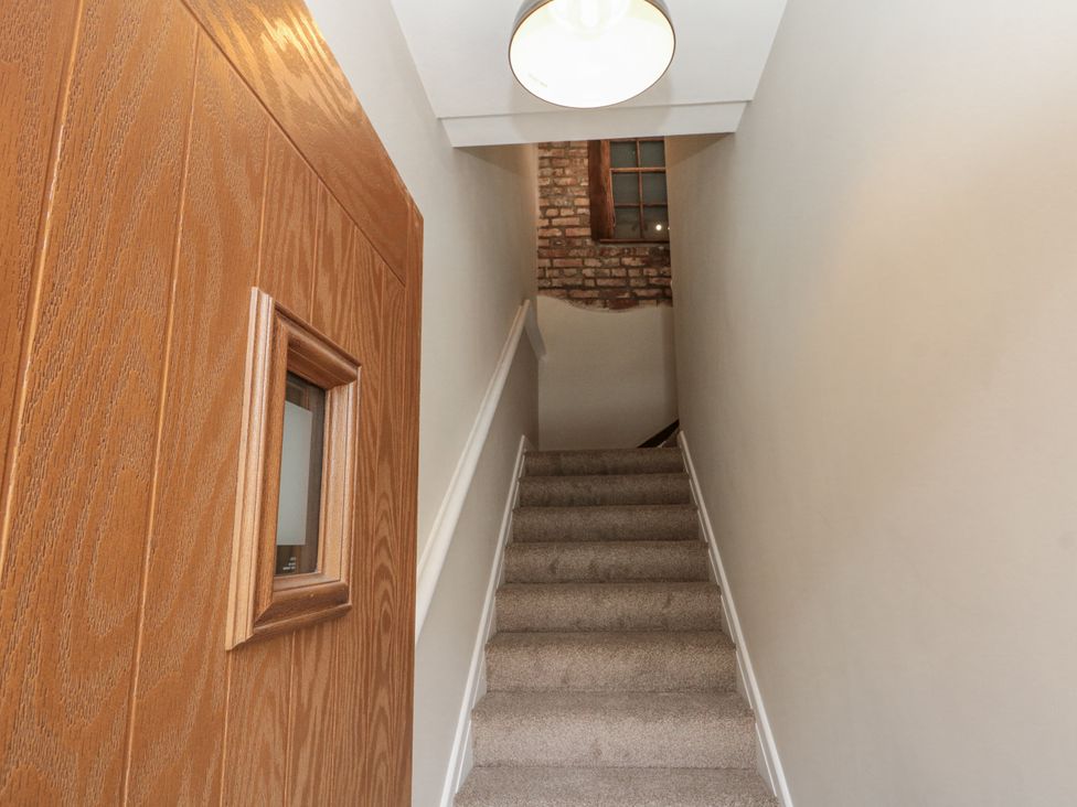 A staircase with a door at the bottom in Betsy's Burrow