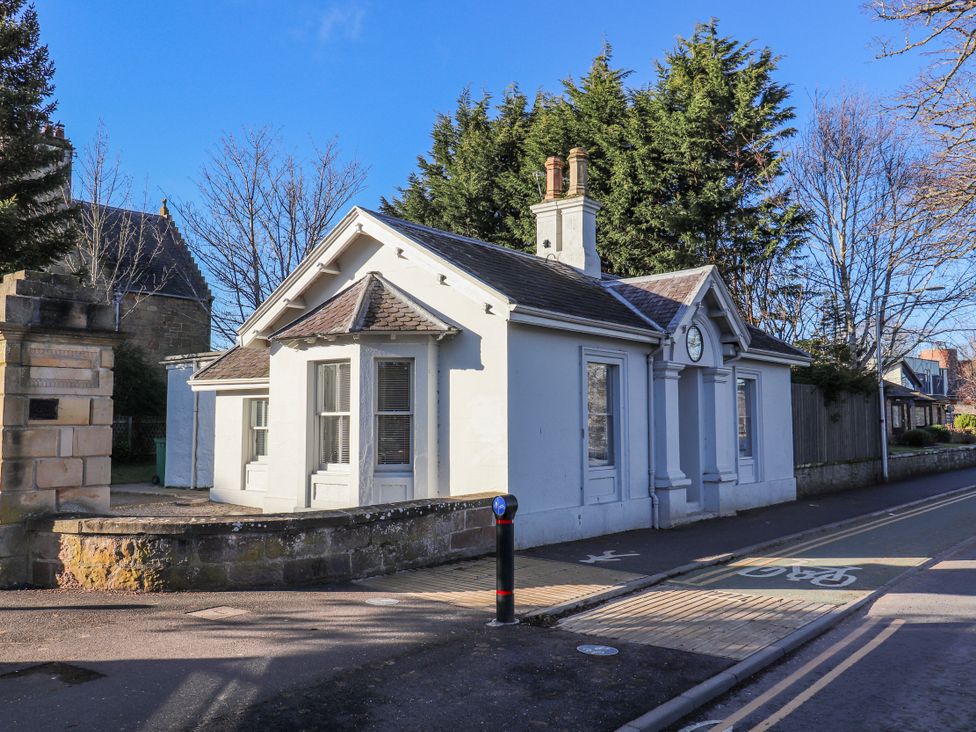 A small building with a clock and trees at Porter's Lodge Inverness