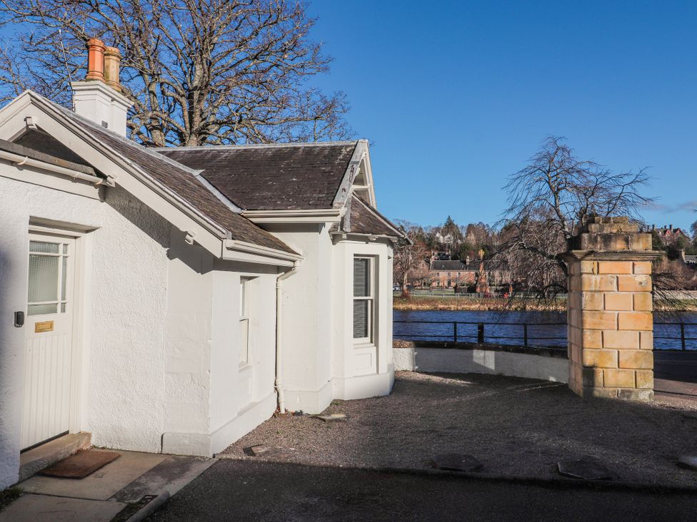A house exterior with a door and window near a river at Porter's Lodge Inverness