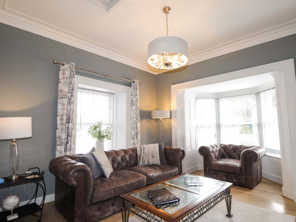 A living room with a sofa and armchair at Porter's Lodge in Inverness