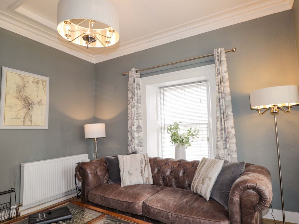 A living room with a sofa and a lamp at Porter's Lodge in Inverness