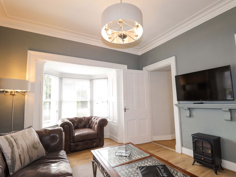 A living room with a sofa and television at Porter's Lodge in Inverness