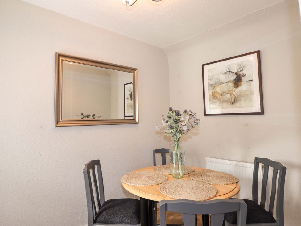 A dining room with a table and chairs at Porter's Lodge Inverness