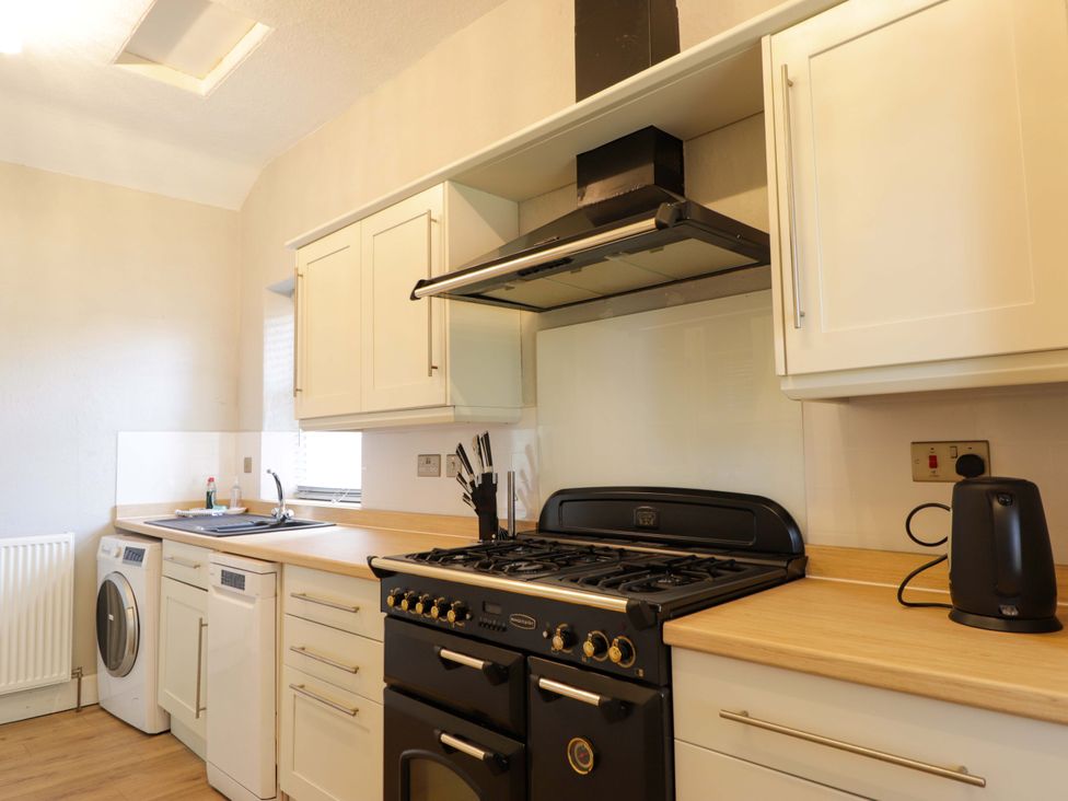 A kitchen with an oven and washing machine at Porter's Lodge in Inverness
