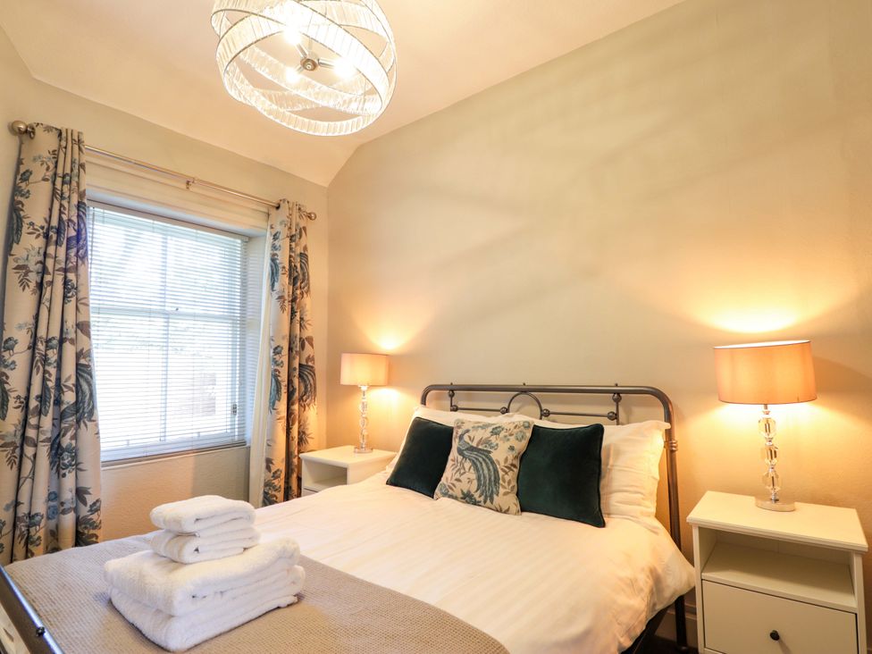 A bedroom with a bed and bedside tables at Porter's Lodge in Inverness